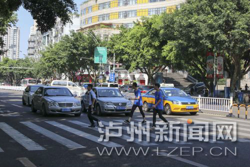 四川警察學(xué)院前的斑馬線沒有紅綠燈，但過往車輛見到有行人過斑馬線都會禮讓行人